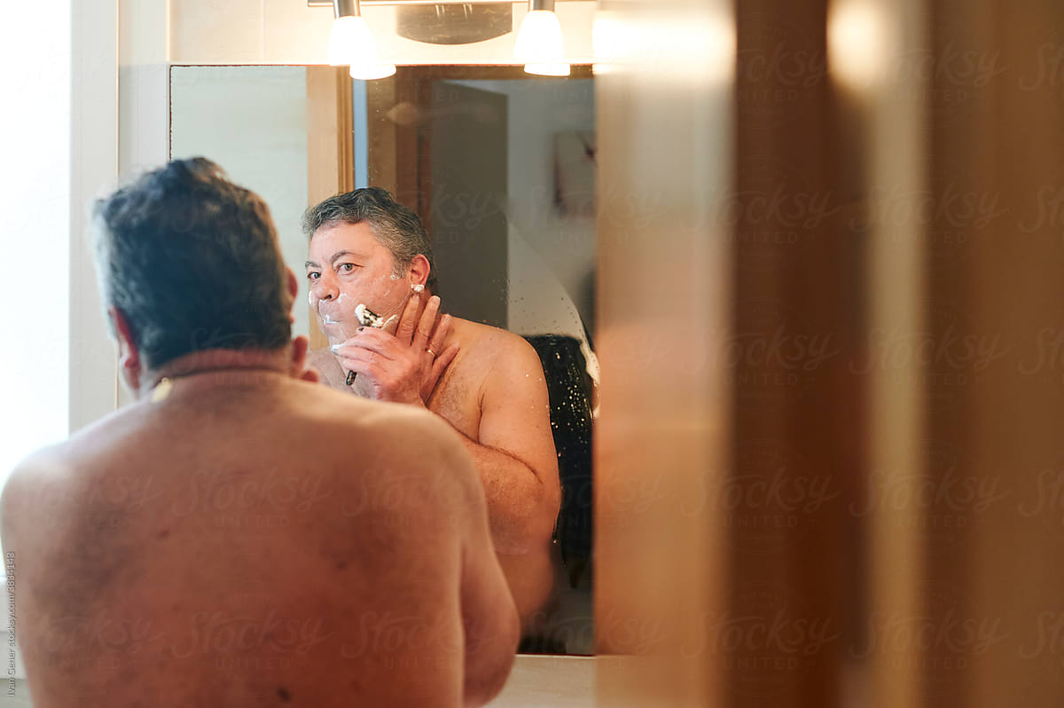 Mature man shaving in his bathroom
