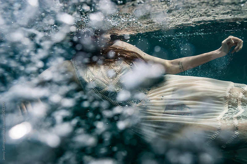 Underwater photo of Beautiful woman swimming in boho dress