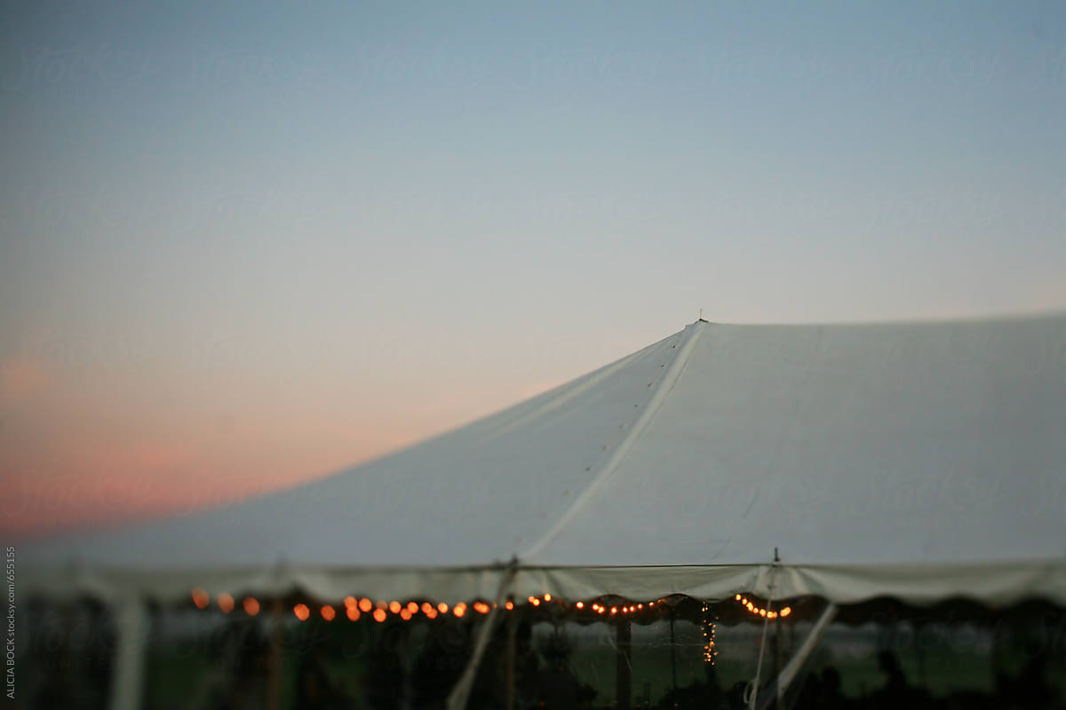 A Large Tent Where People Are Gathered For A Party On A Summer Evening