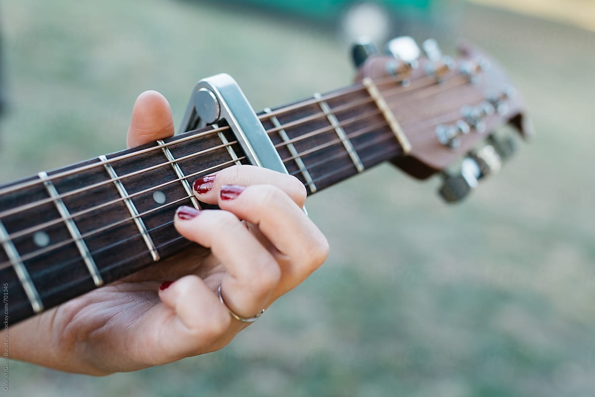 Girl\'s hand on an acoustic guitar