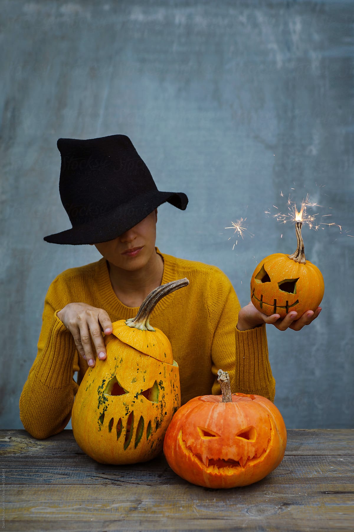 Woman in hat with Halloween pumpkins