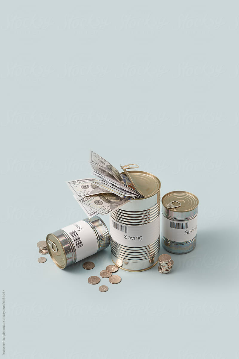 Savings cans with dollars and coins.