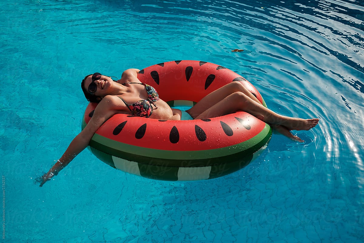 Happy Young Woman Sitting In Inflatable Tube In The Swimming Pool