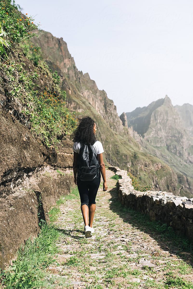 back view of black backpack woman hiking in mountains in Cape verde