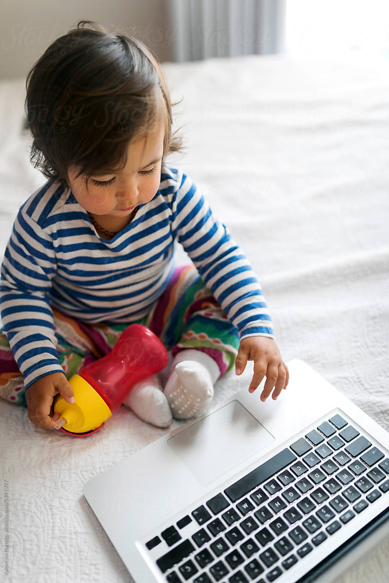 little girl playing with laptop
