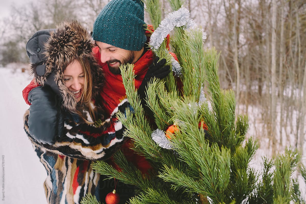 Playful couple next to christmas tree