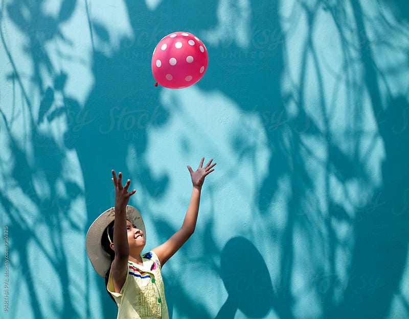 Girl playing with a red balloon