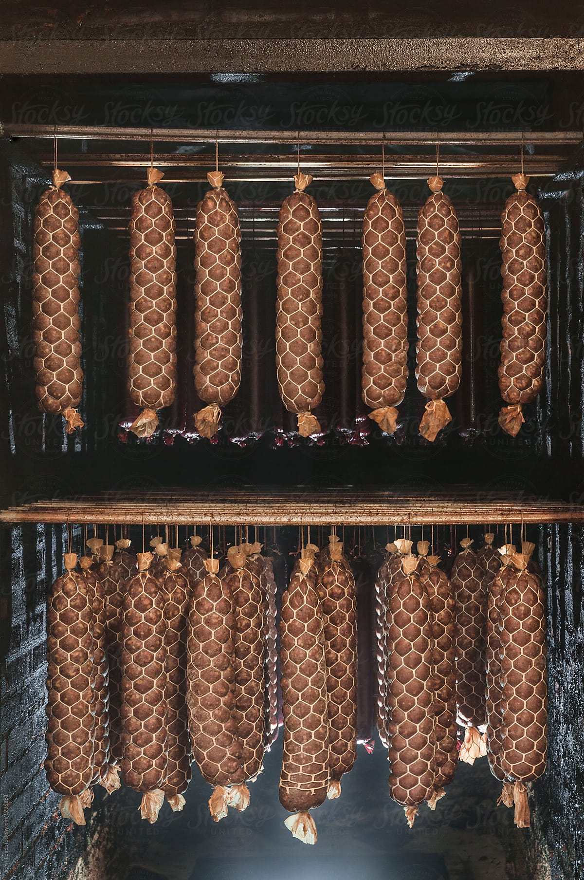 Large aged sausage hanging in smoke chamber