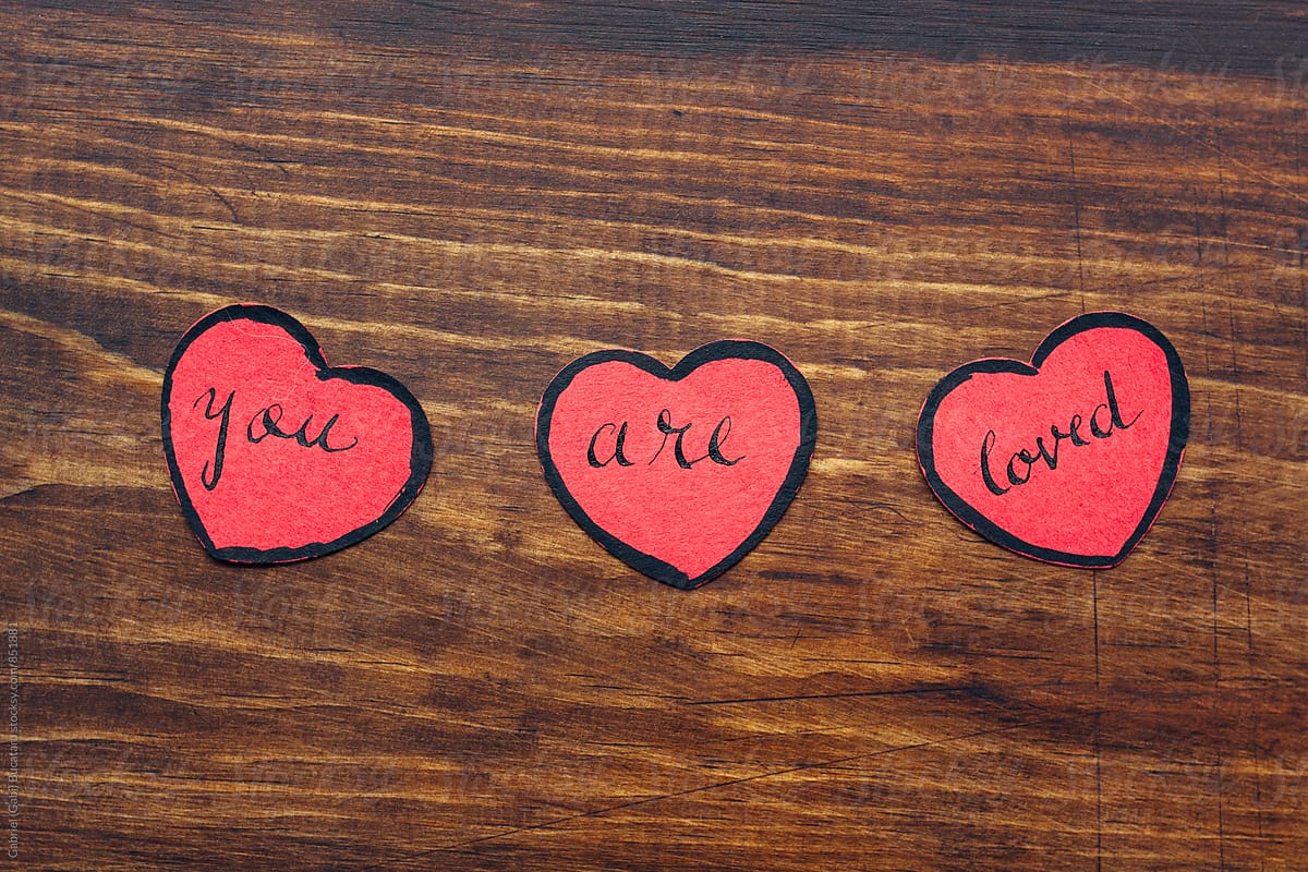 Three red paper hearts with the message 