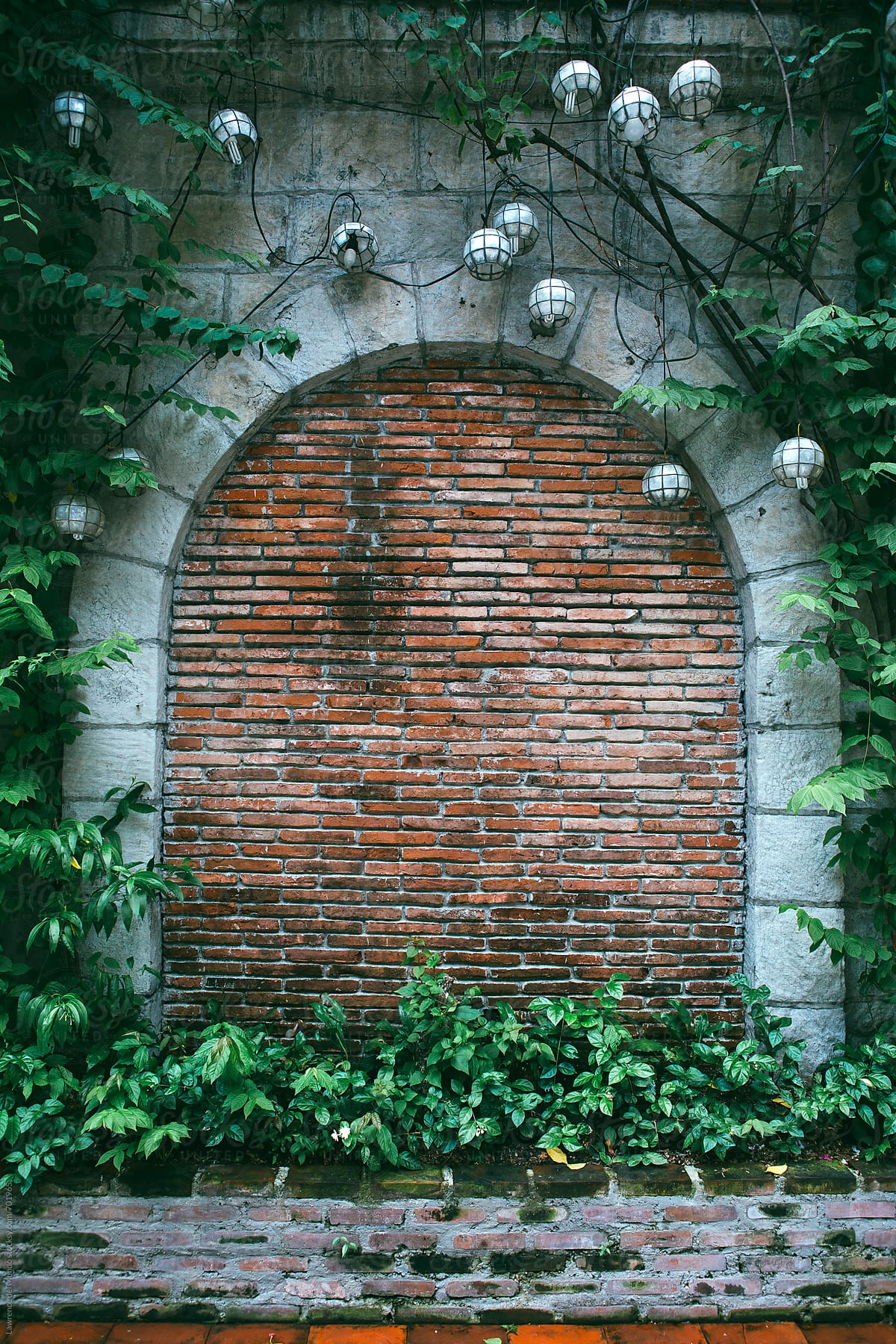 Garden arch opening elegantly covered and \'boarded up\' with red bricks.