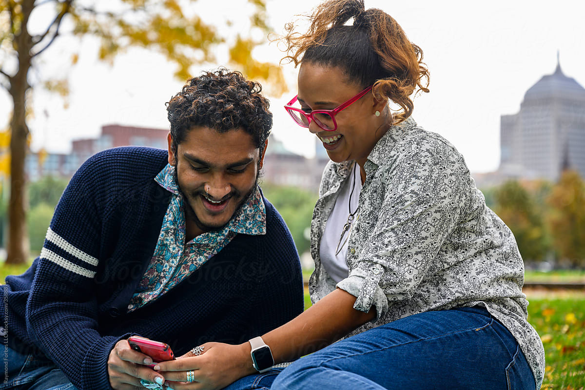 Young Black  Couple Talking together  and looking at Mobile phone
