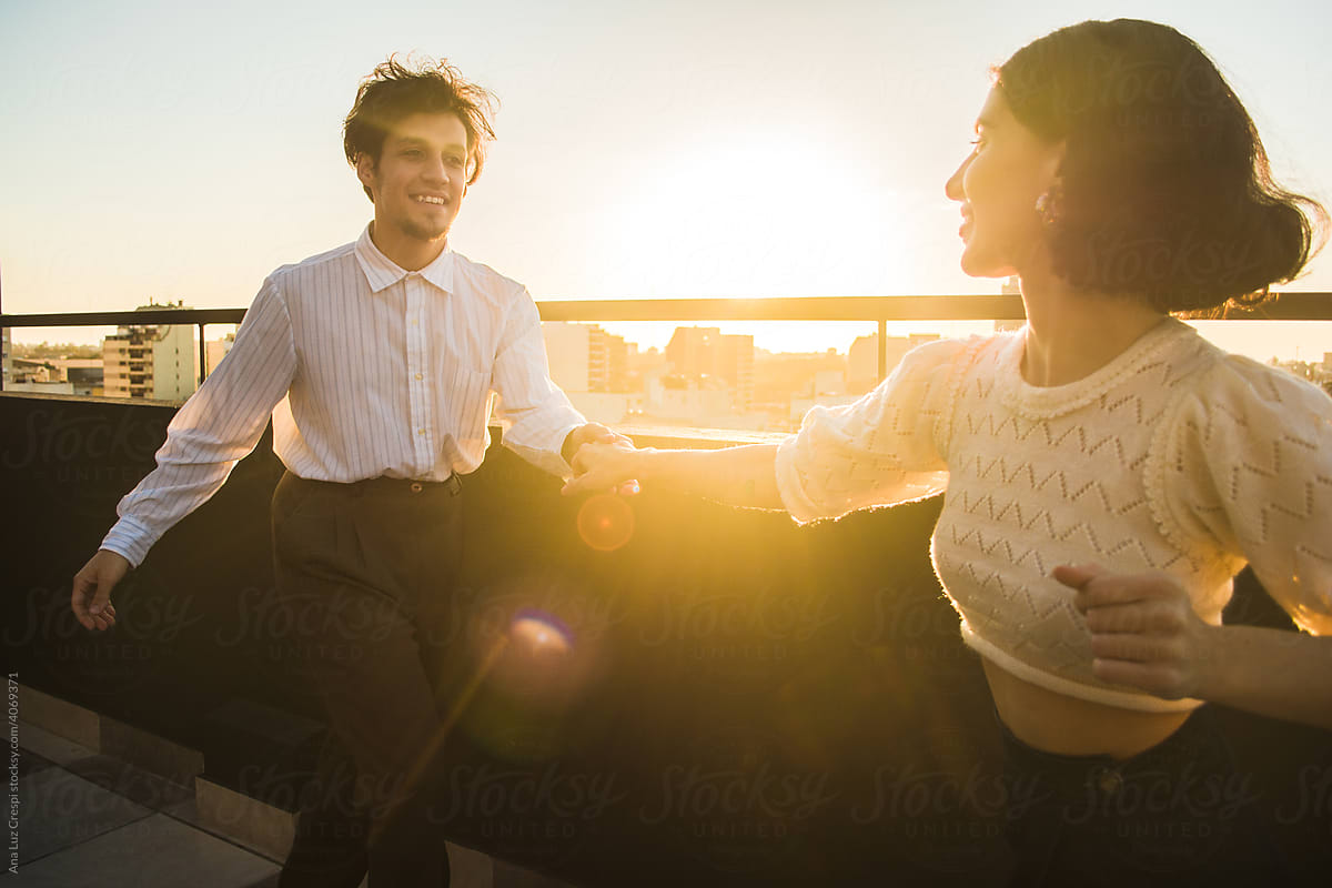 Couple swing dancing in a terrace at sunset