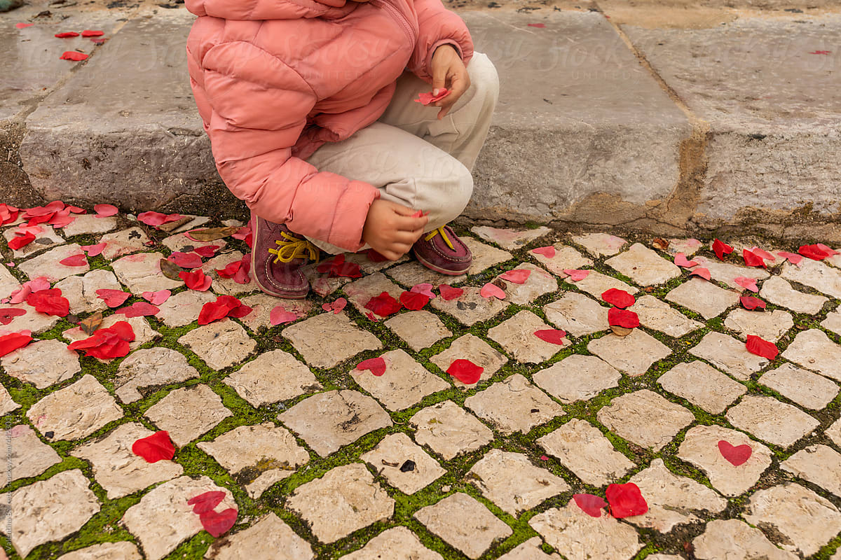 Girl putting silk hearts on pavement