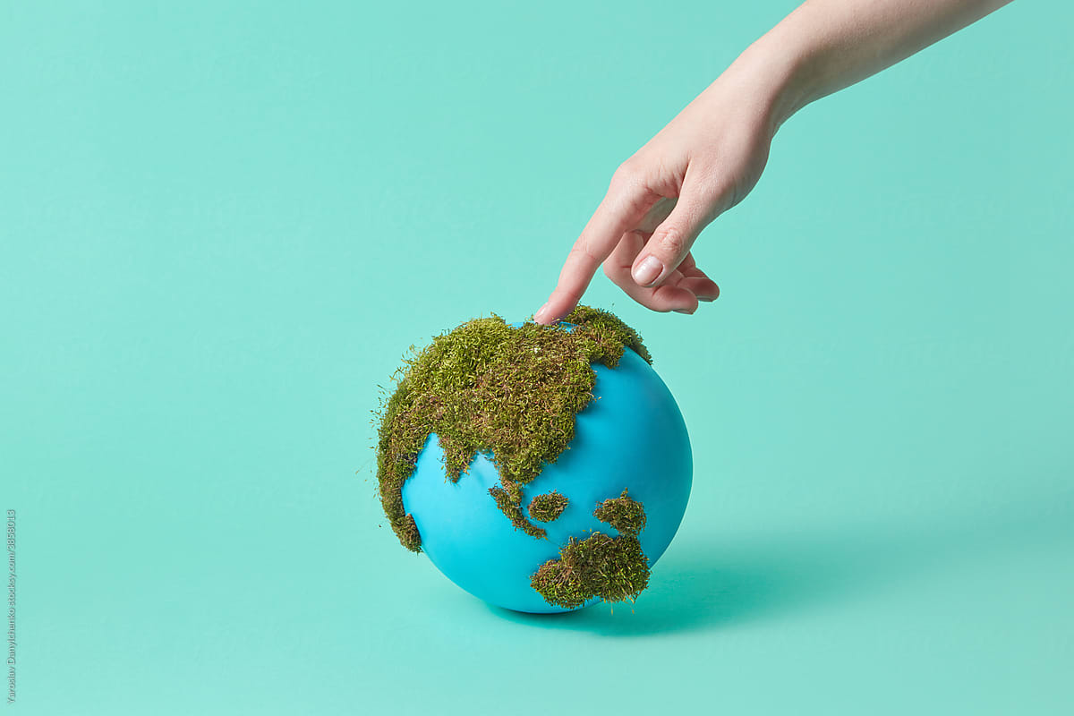 Woman touching earth globe with green moss