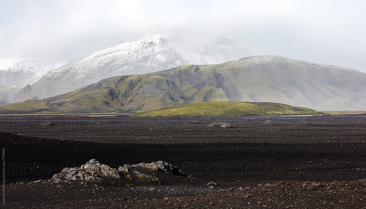 Snow covered mountains across a field of volcanic ash