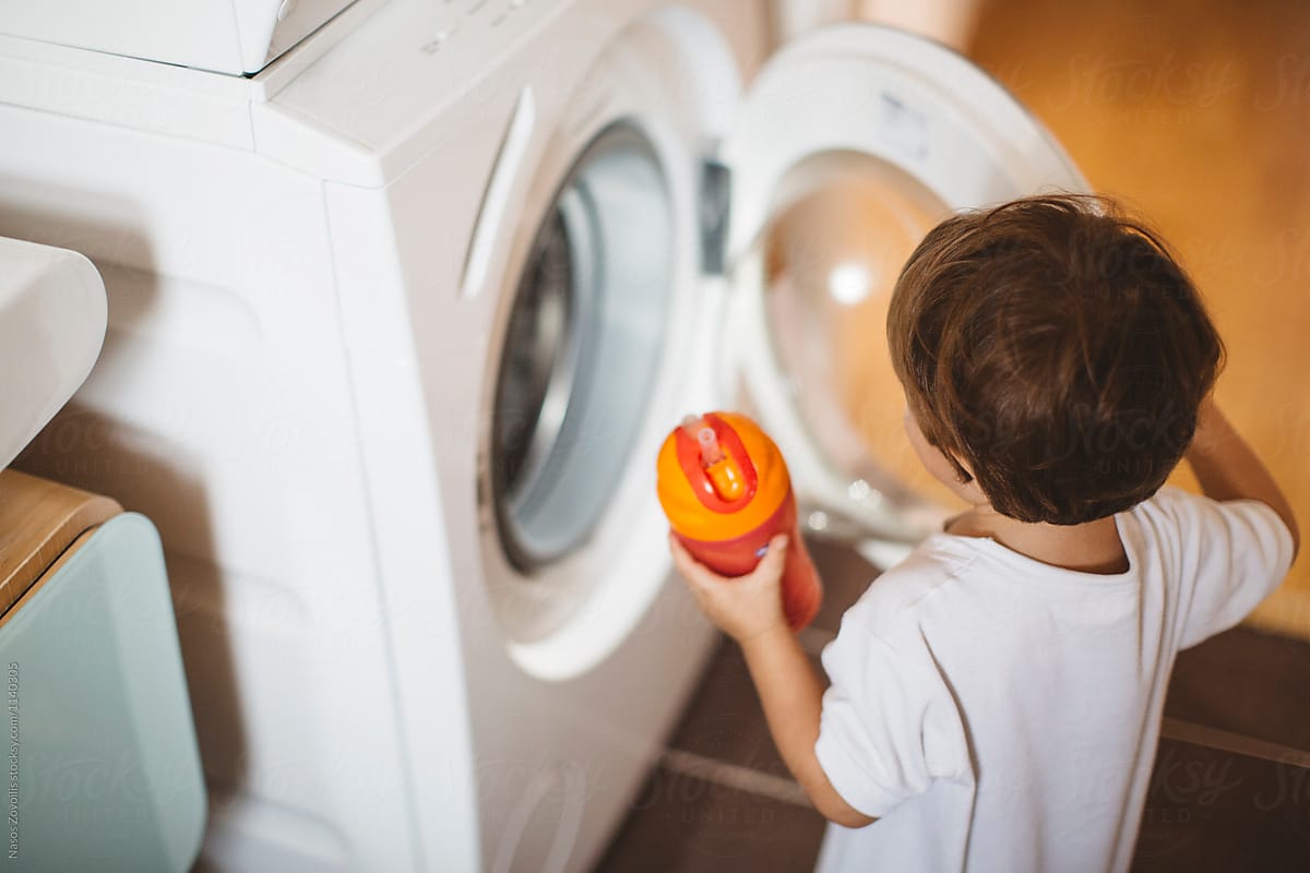 1 year old boy looking a washing machine