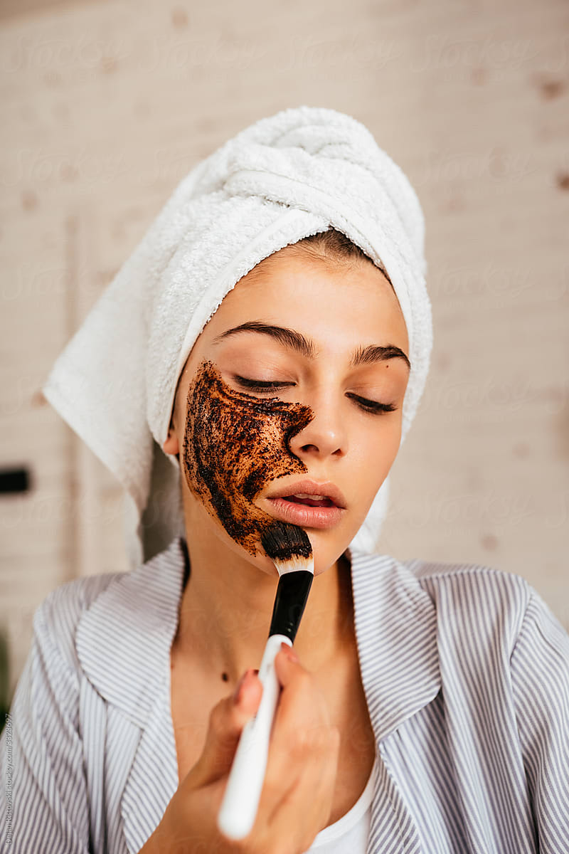 Girl taking a face care treatment with coffee scrub mask