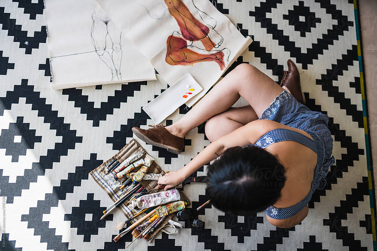 Female artist painting on floor