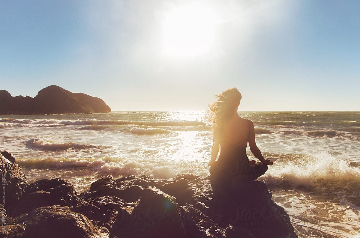 Pretty Woman Meditating by the Ocean