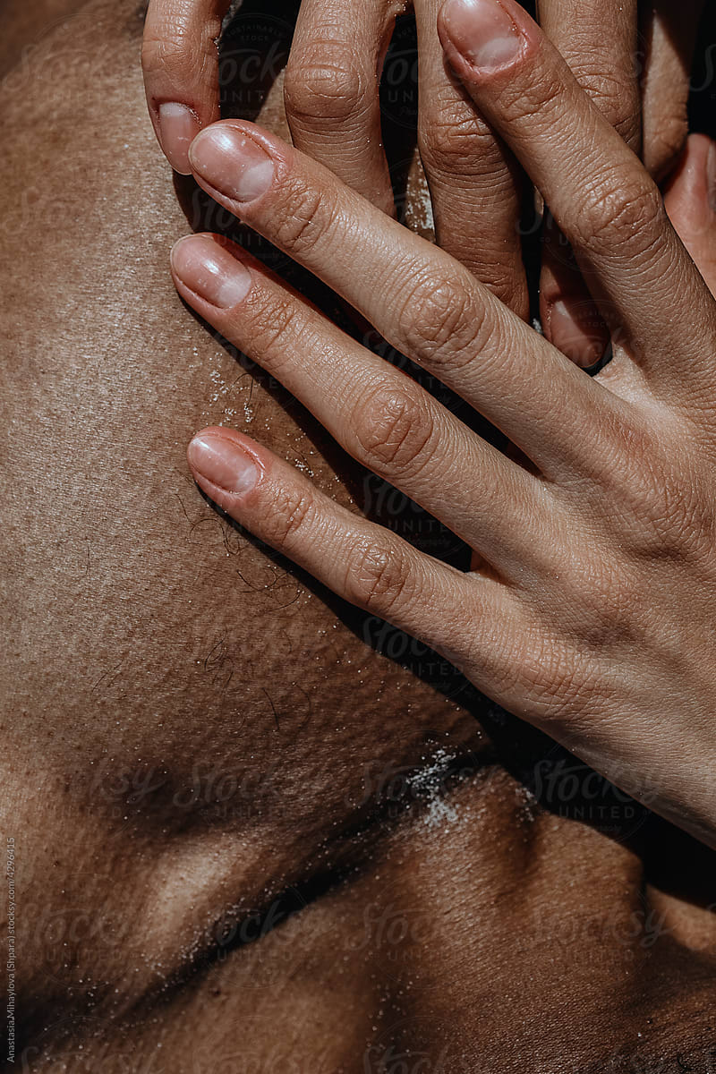 The hand of white woman lying on the chest of black man