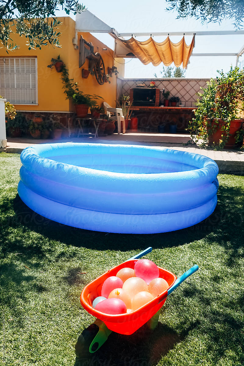 Inflatable pool and water balloons in backyard