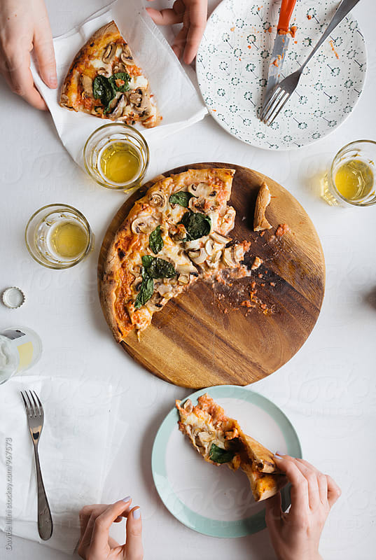 Two People Eating Pizza with mushrooms and basil