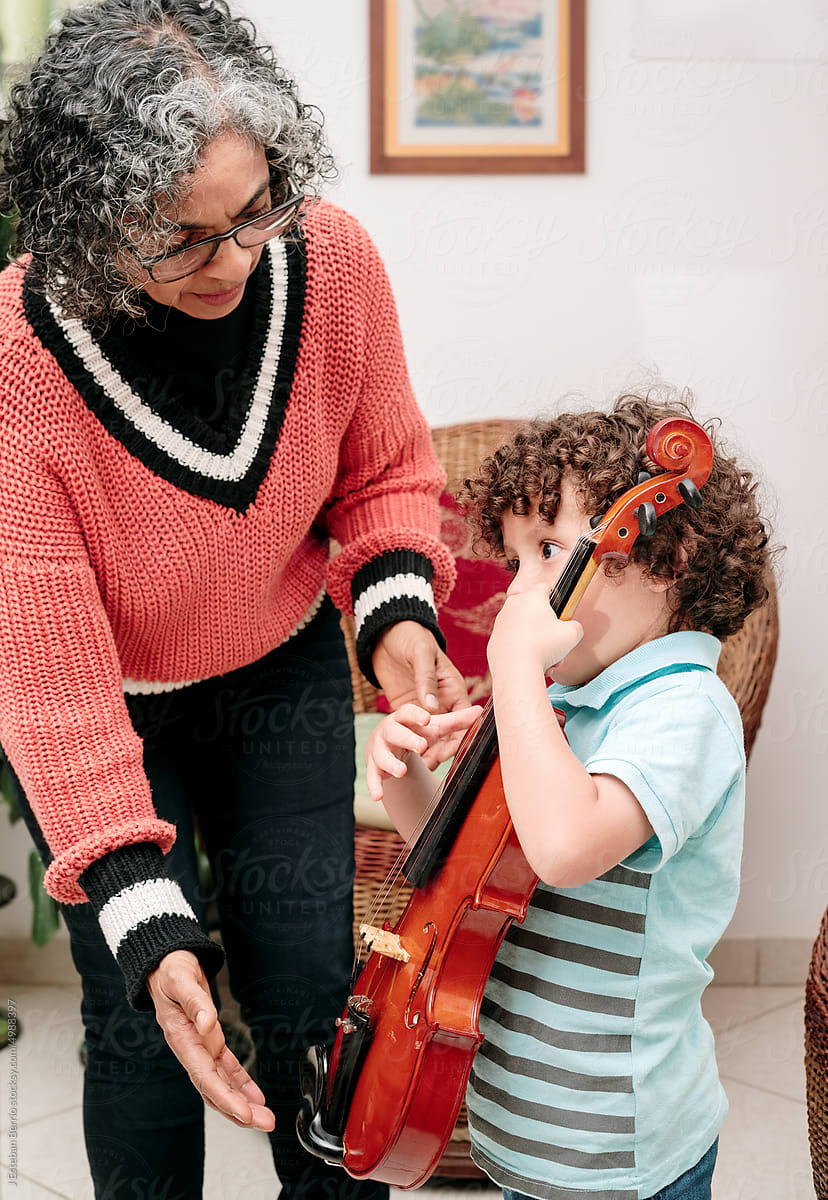 Boy holding a violin with his grandmother