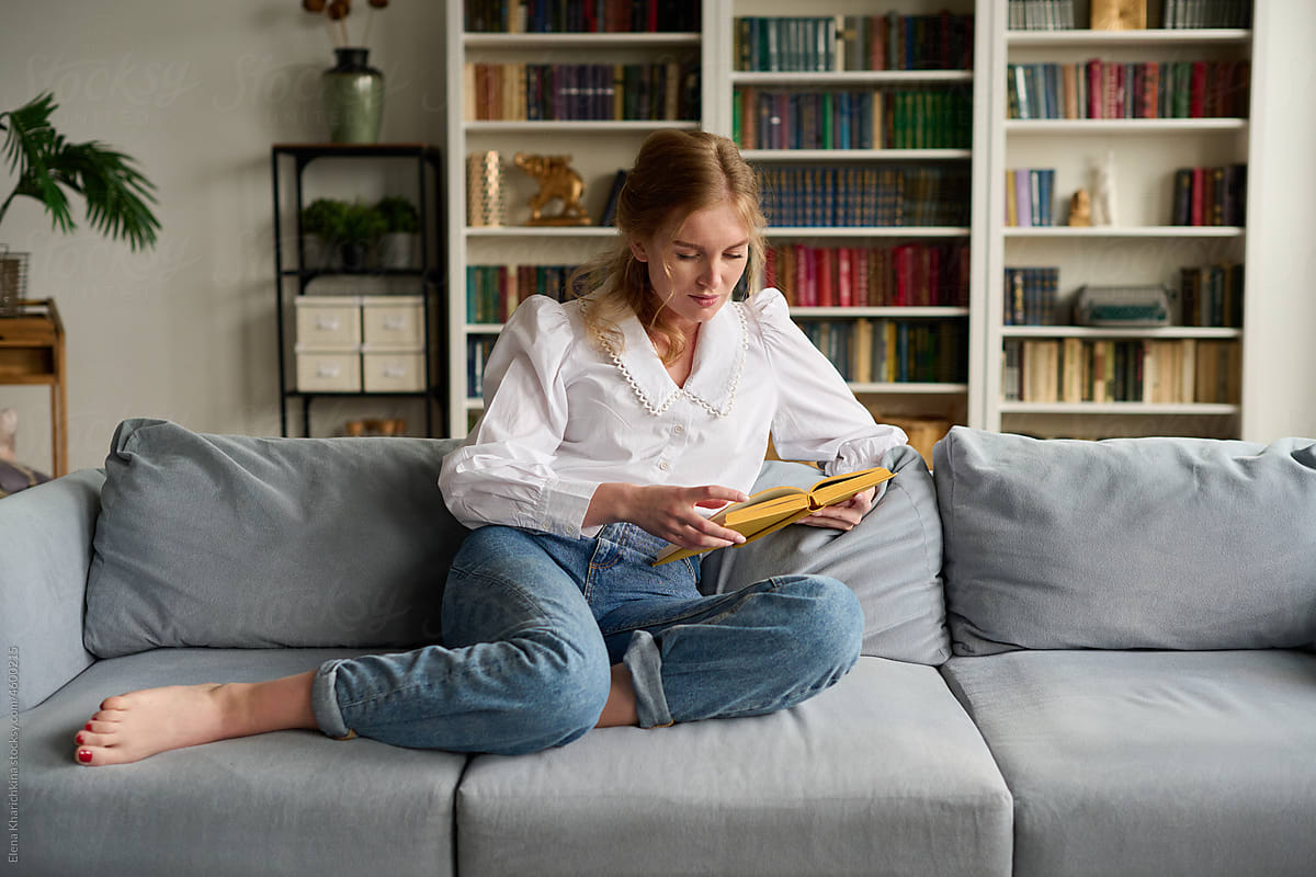 Woman reading book in living room