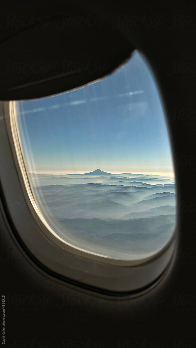 A view of a smokey mountain range from an airplane window
