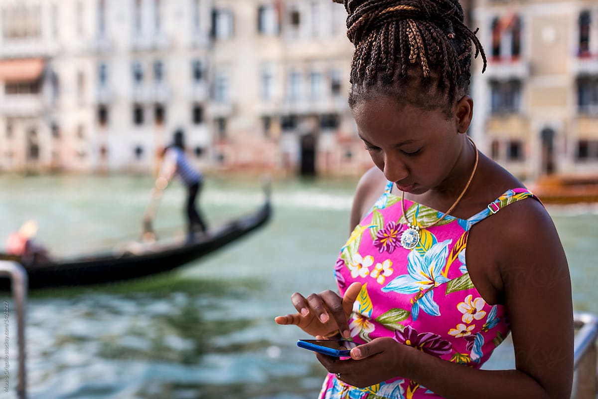 Black Woman using mobile phone in Venice, Italy.