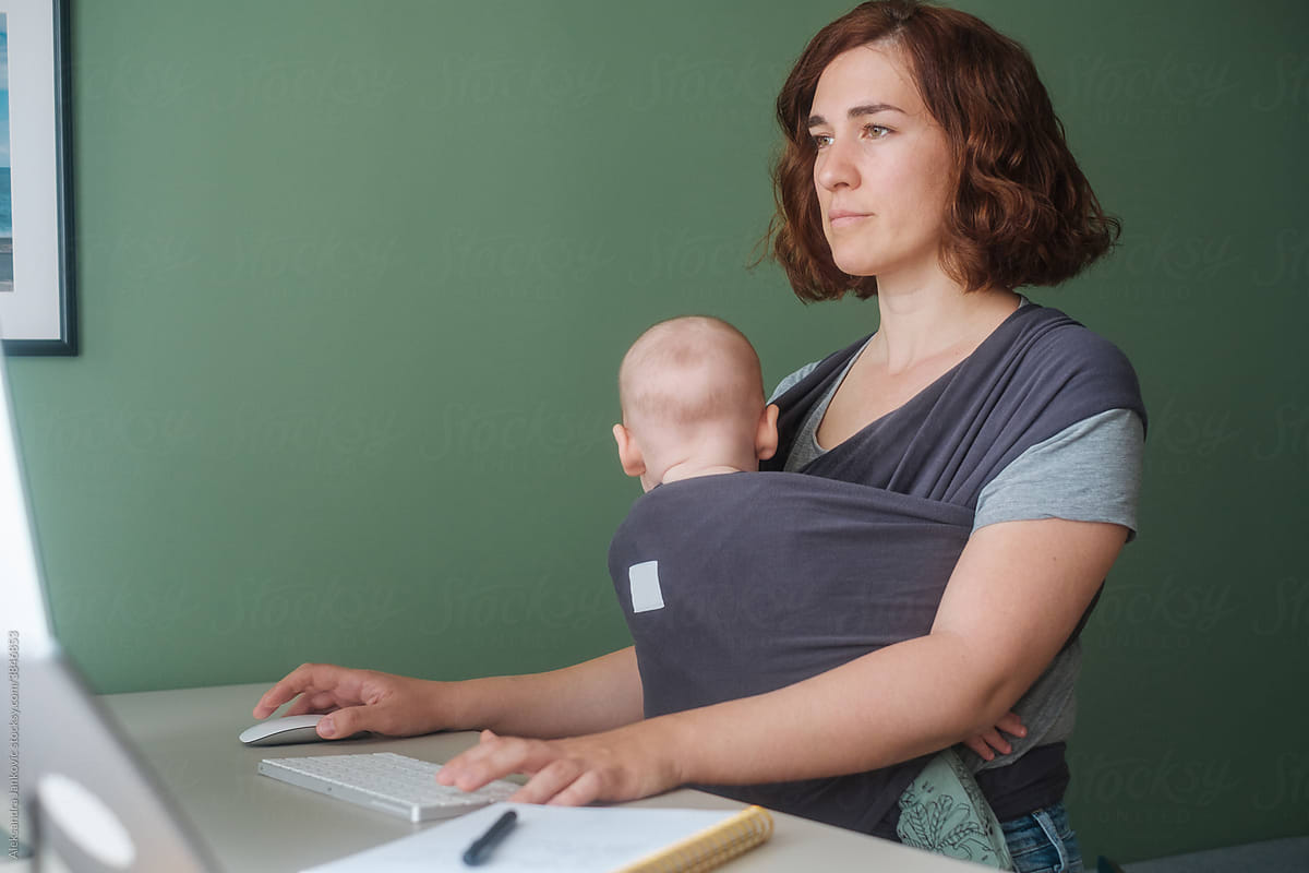 Woman With A Baby Using Computer