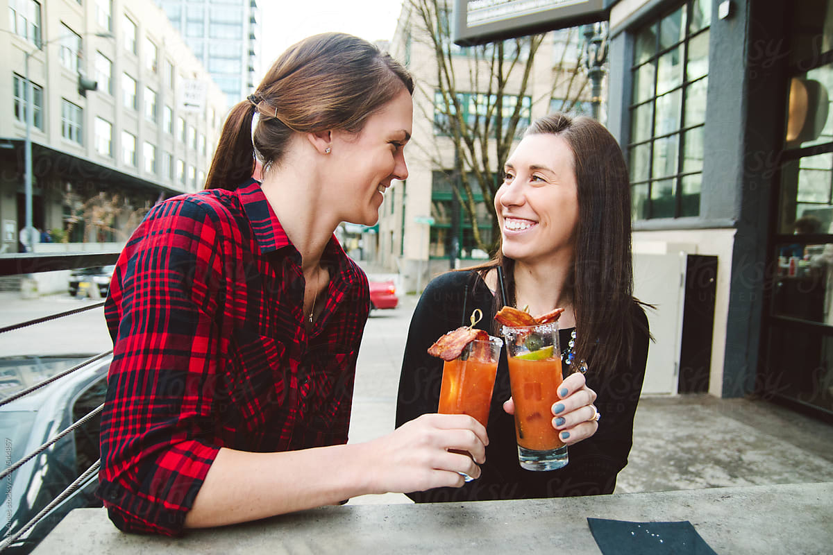 Young Beautiful Lesbian Couple Enjoying Drinks At An Outdoor Bar
