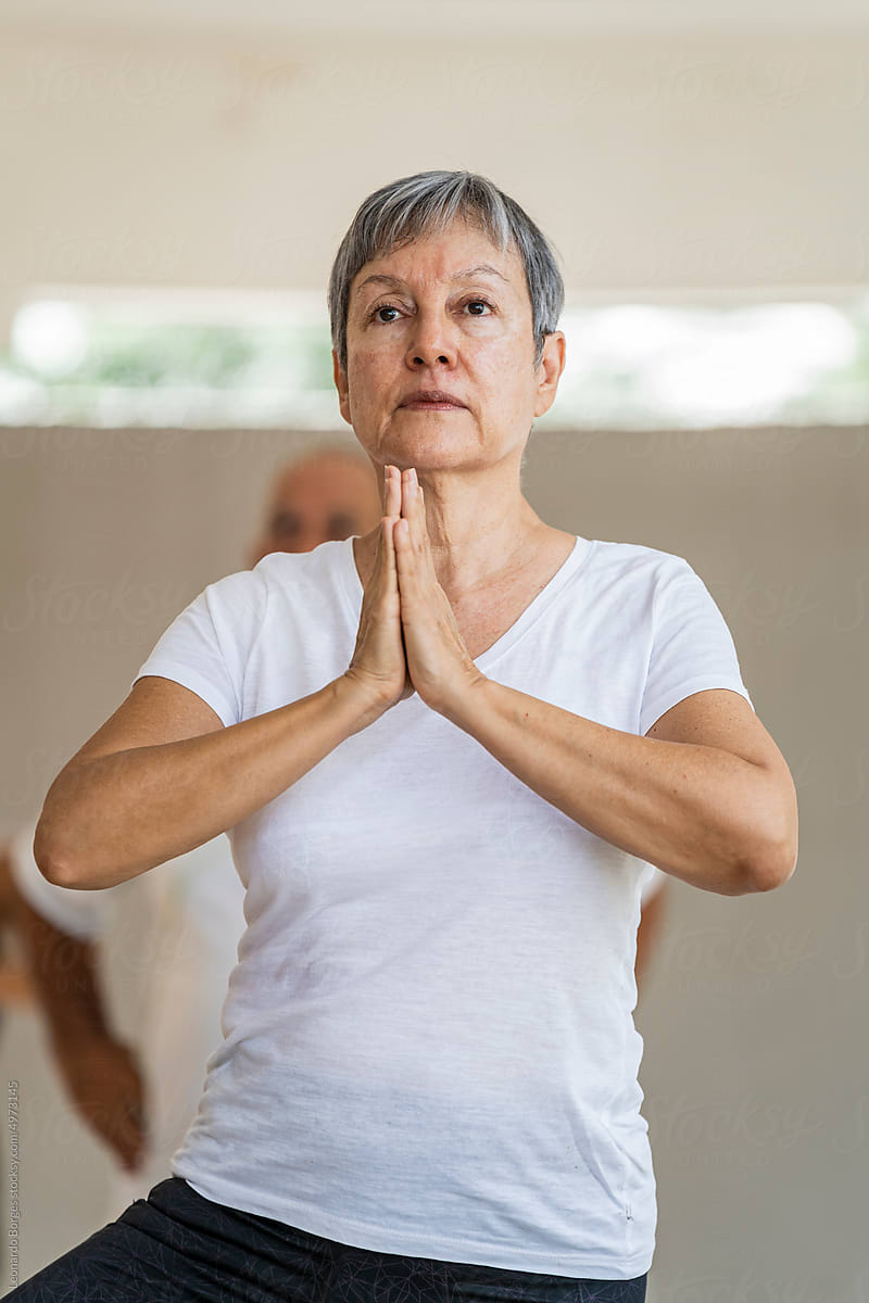 Standing student performing mudras in yoga class