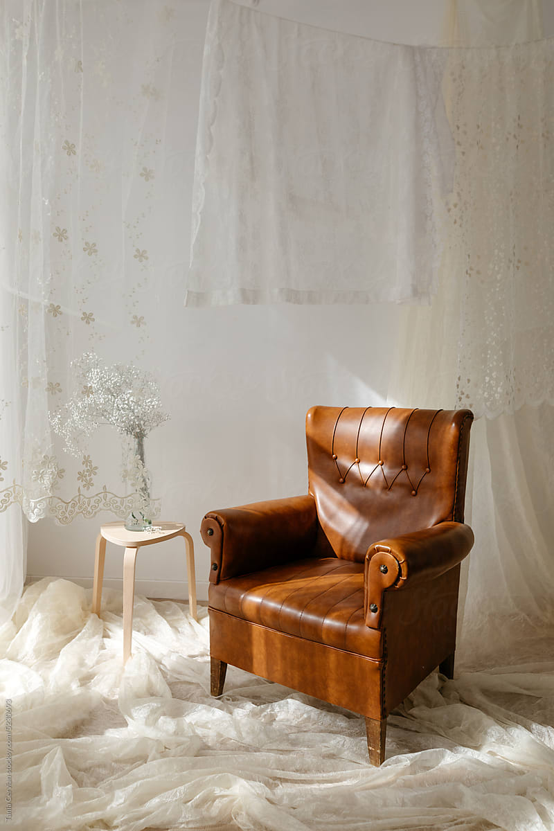 Vintage armchair in room with white curtains