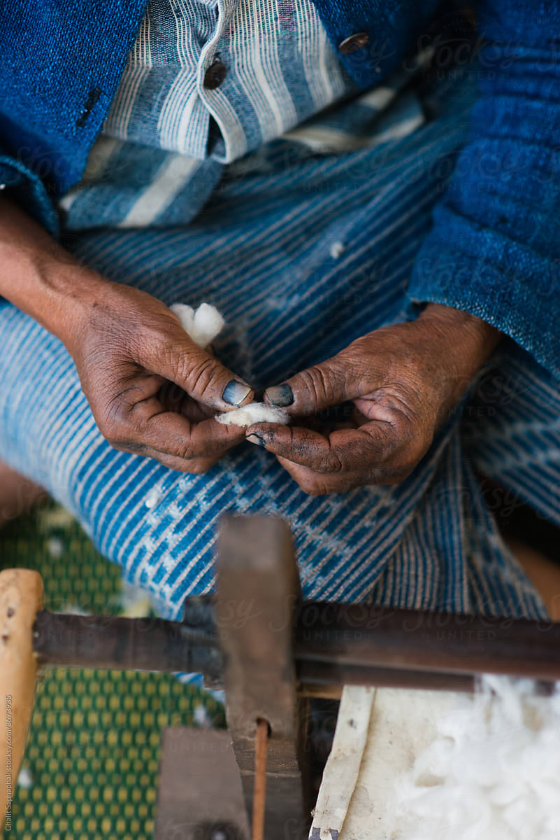 The old woman was separating cotton to make thread.