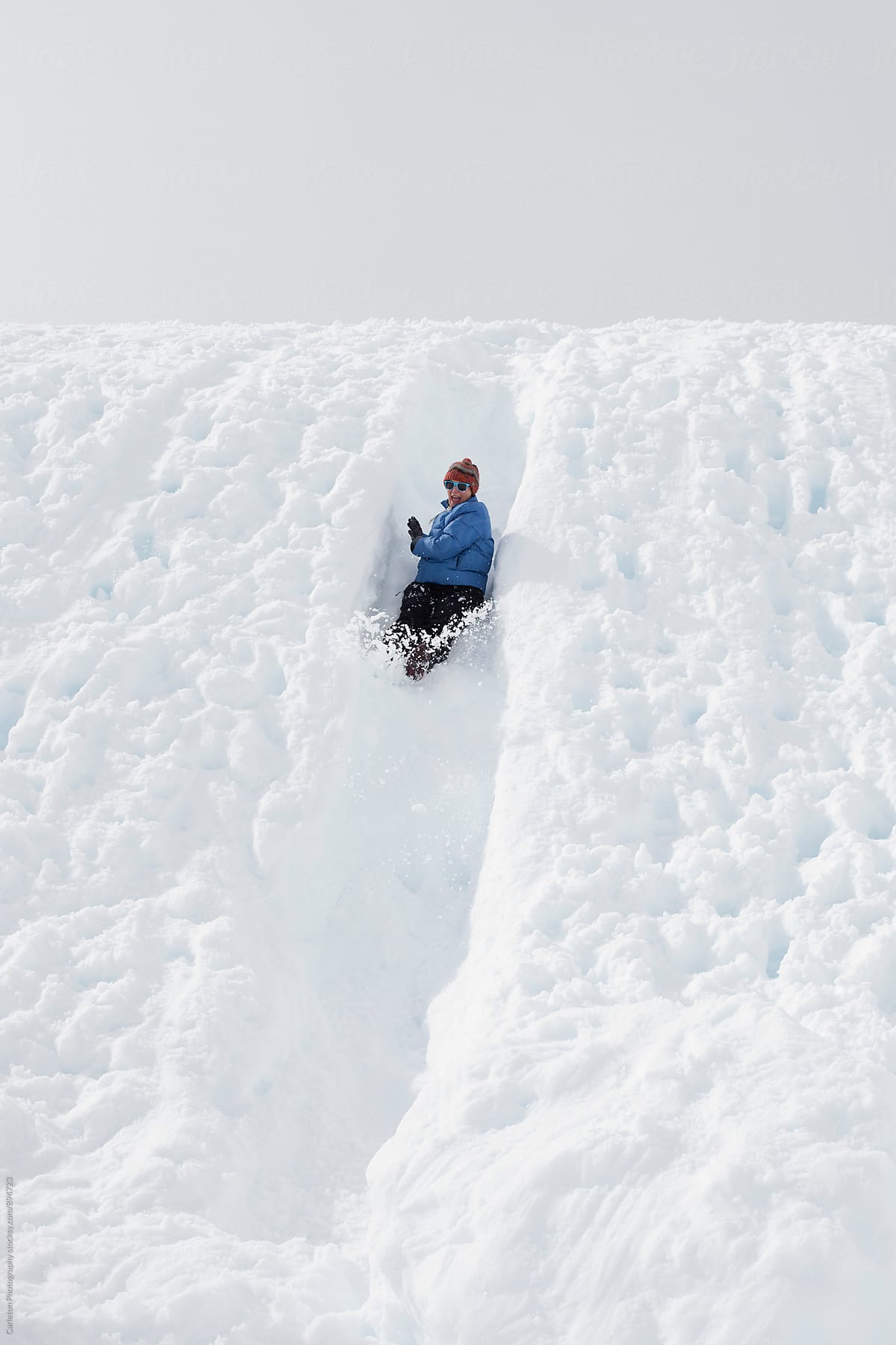 Woman sliding down a snow chute and enjoying the ride