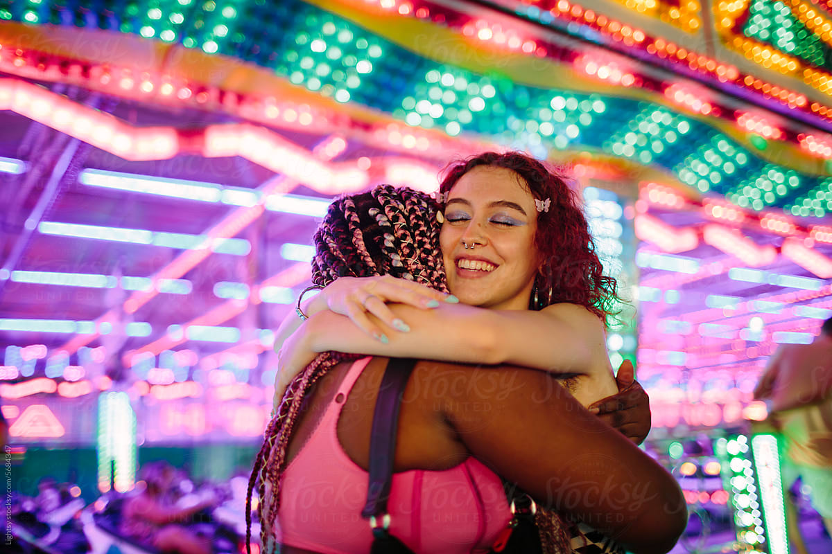 Friends hugging each other at a fair