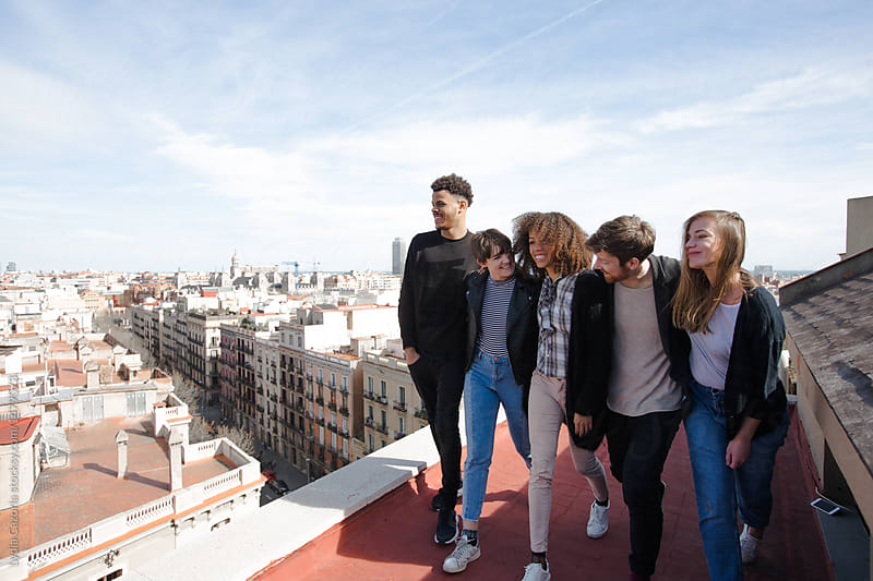 Young people observing embracing on a roof top of a building of Barcelona city