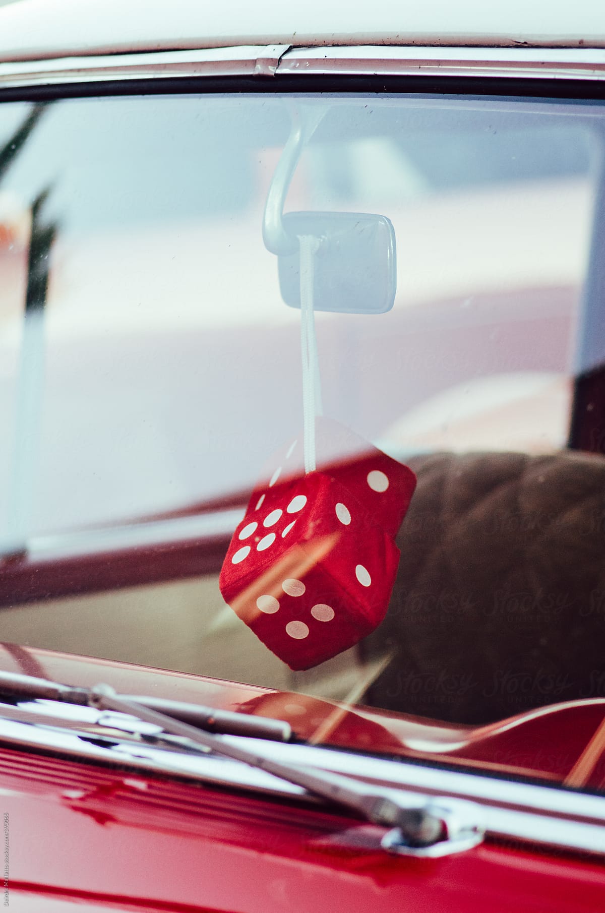 fuzzy red dice in a classic red car