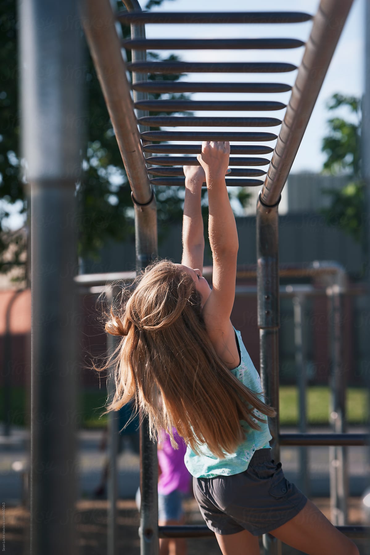 Recess: Schoolgirl Hanging From Playground Monkey Bars by Sean Locke