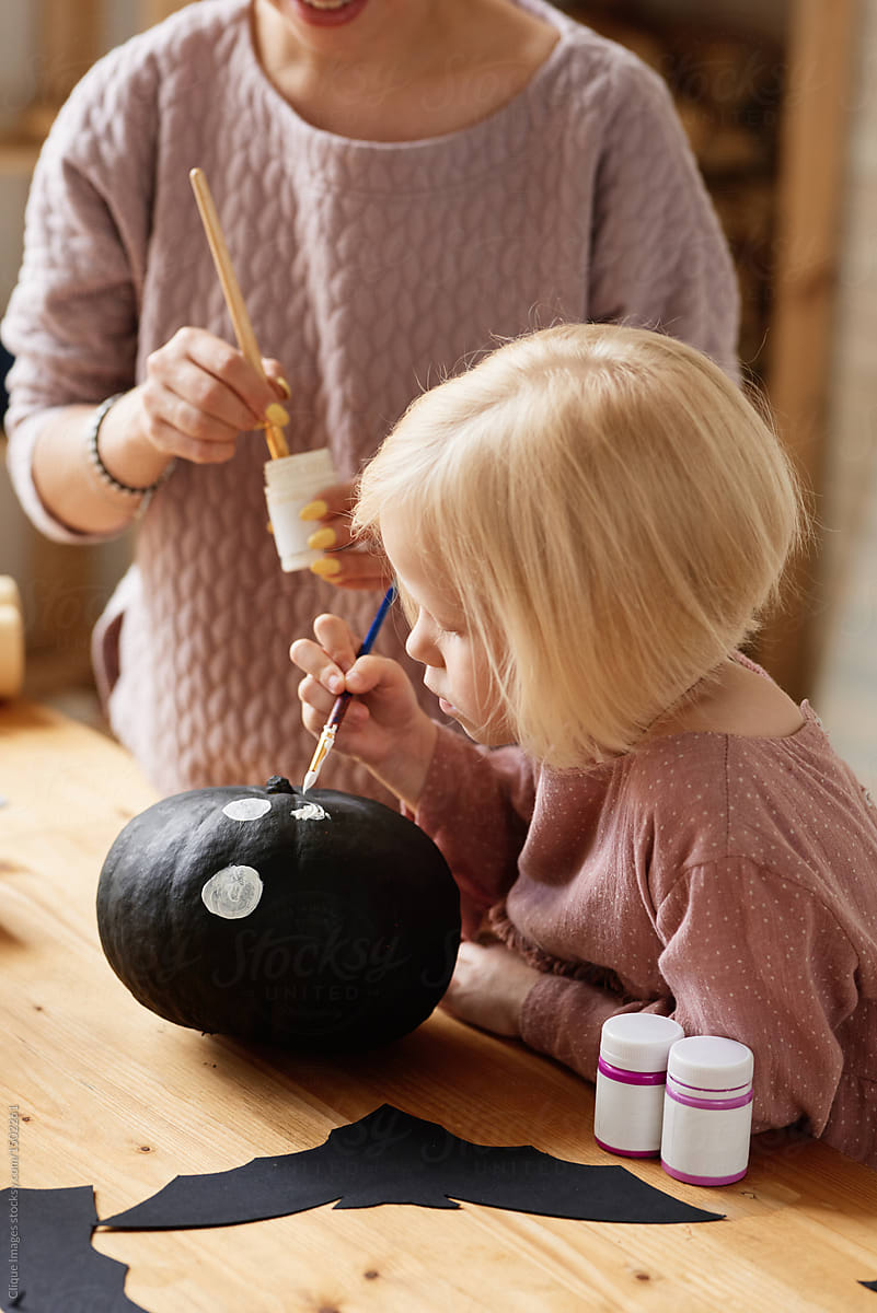 Kid painting pumpkin for Halloween