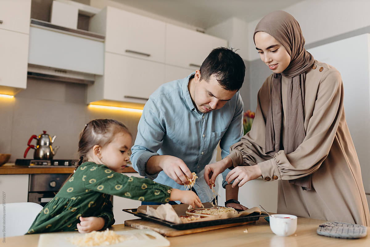 Islamic parents and daughter making pizza together