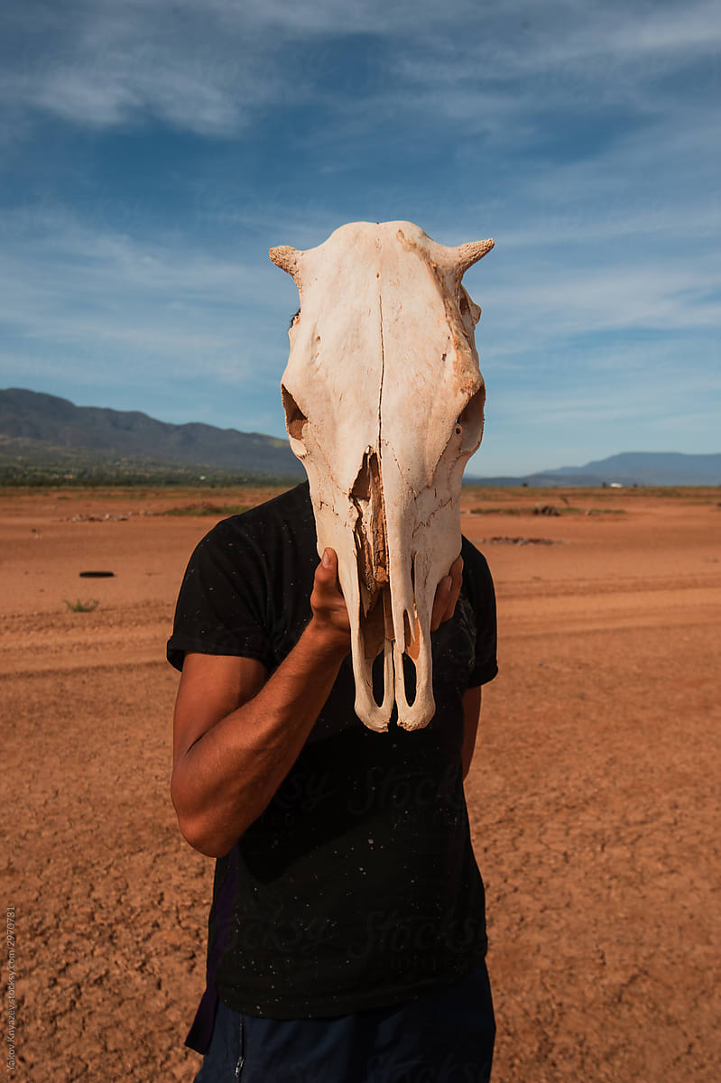Young Man With A Cow Skull In The Desert