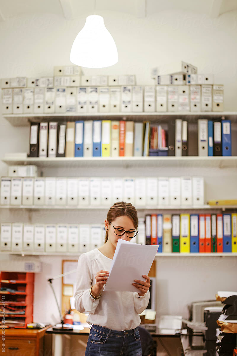 Young businesswoman reading documents at her office.