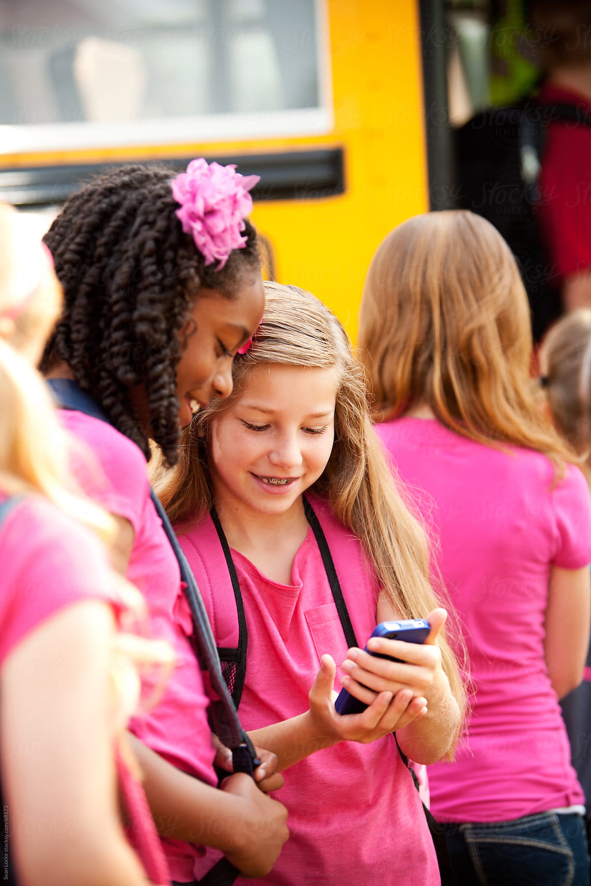 School Bus Girl Shows Friend Funny Text Del Colaborador De Stocksy Sean Locke Stocksy