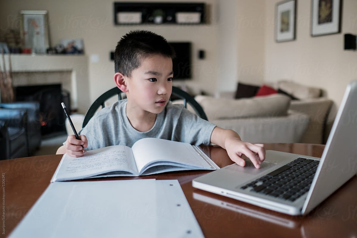 Asian Kid Doing Homework At Home by Take A Pix Media