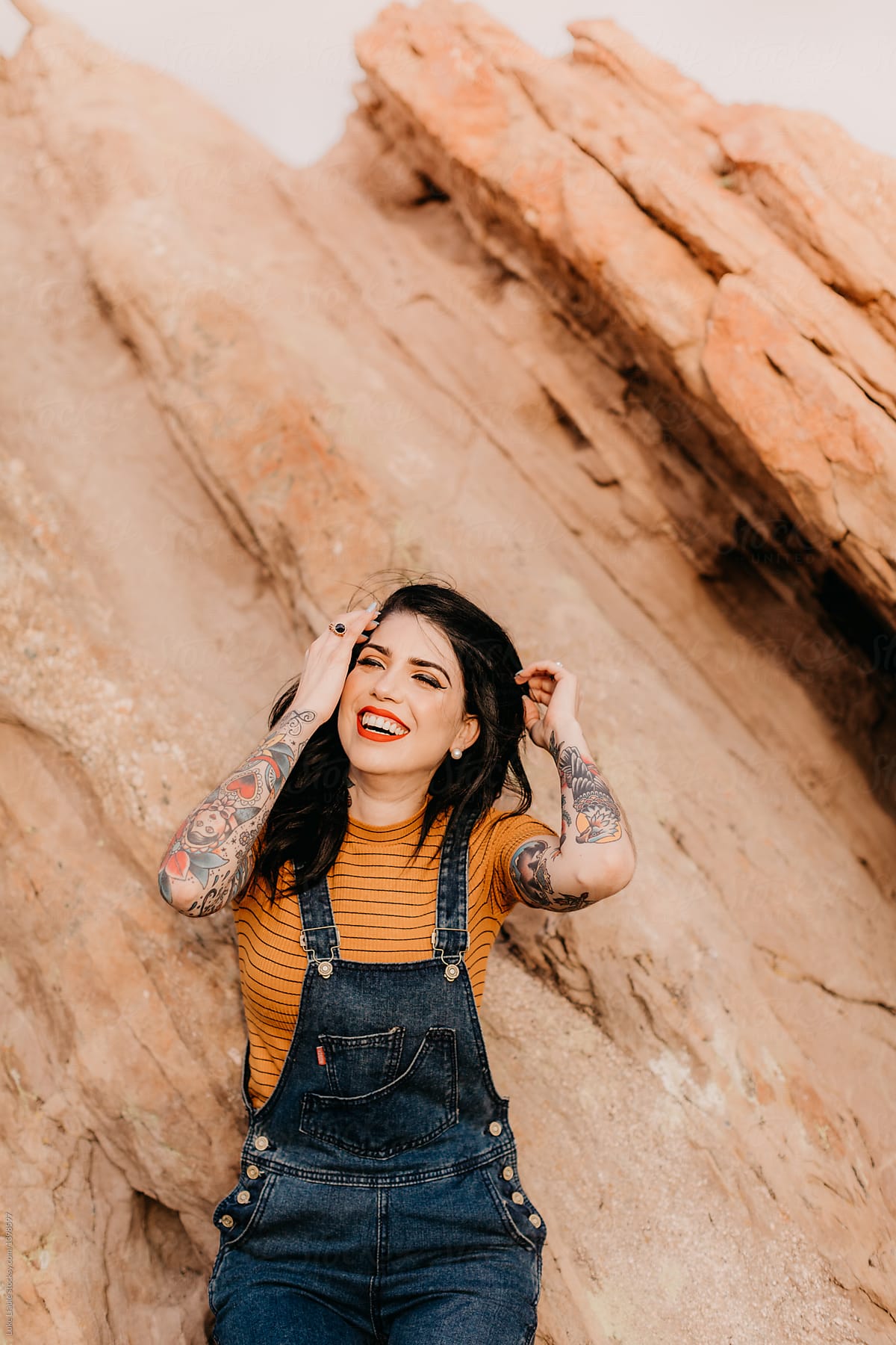 Stylish tattooed women laughing in desert