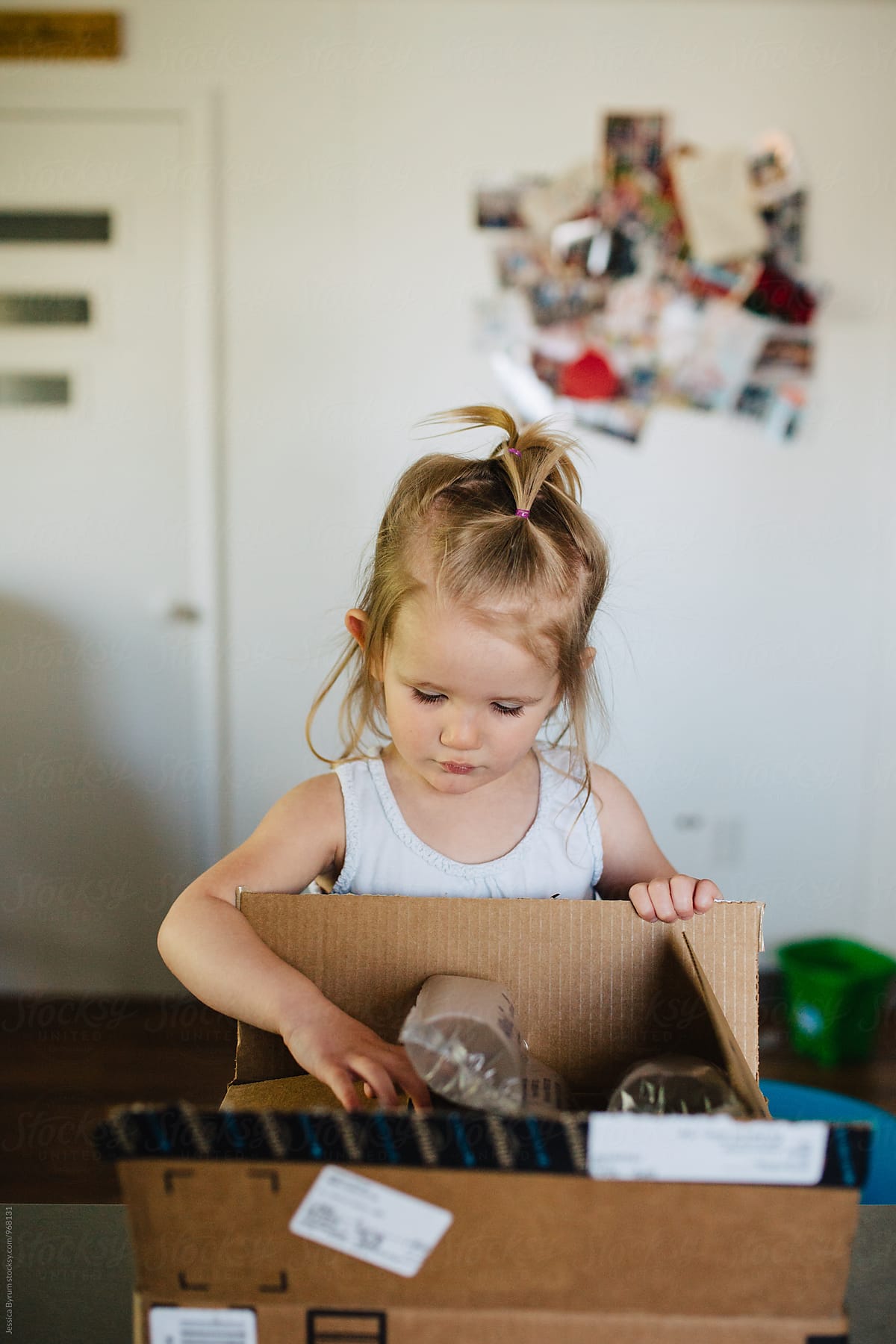 Toddler girl opening box