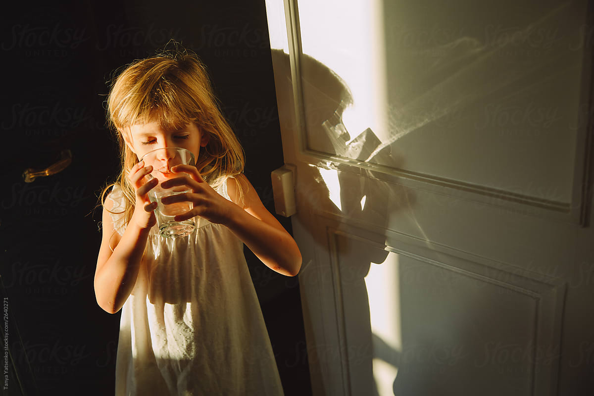 Little girl drinking a glass of water