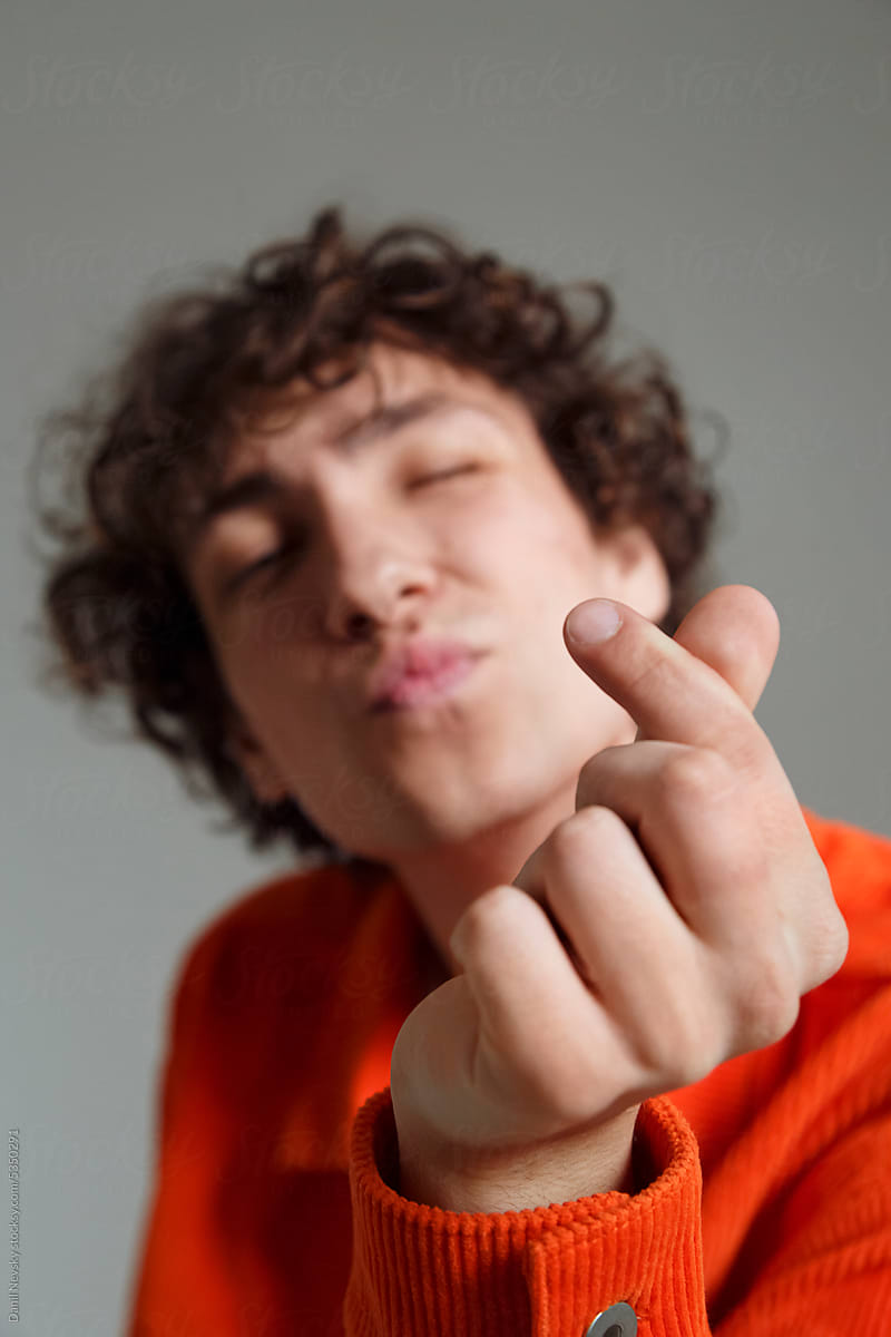 Young guy showing small finger heart